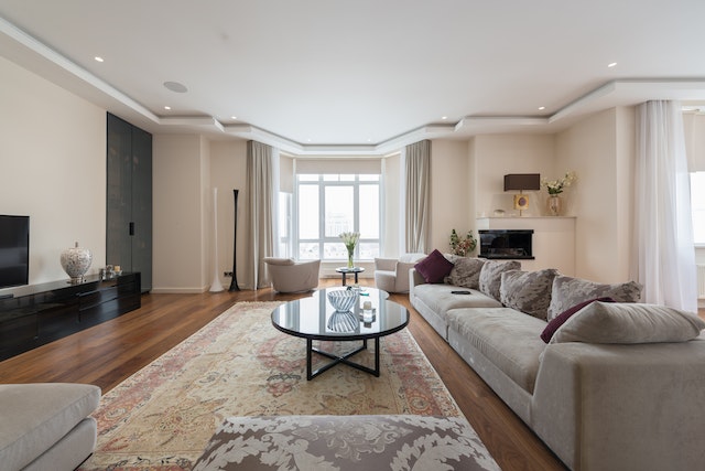 living room with large area rug light grey couch and dark hardwood flooring